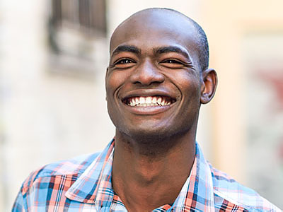 A man with a broad smile is the central focus of this image.